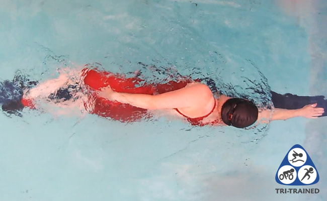 Overhead picture of streamline swim drill in a red swimming costume